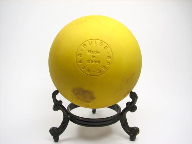 A lacrosse ball on a field.