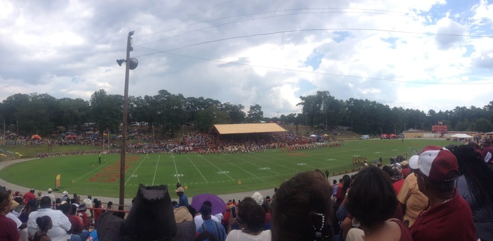 Fans in crimson filling the stands at a Tuskegee University home football game.