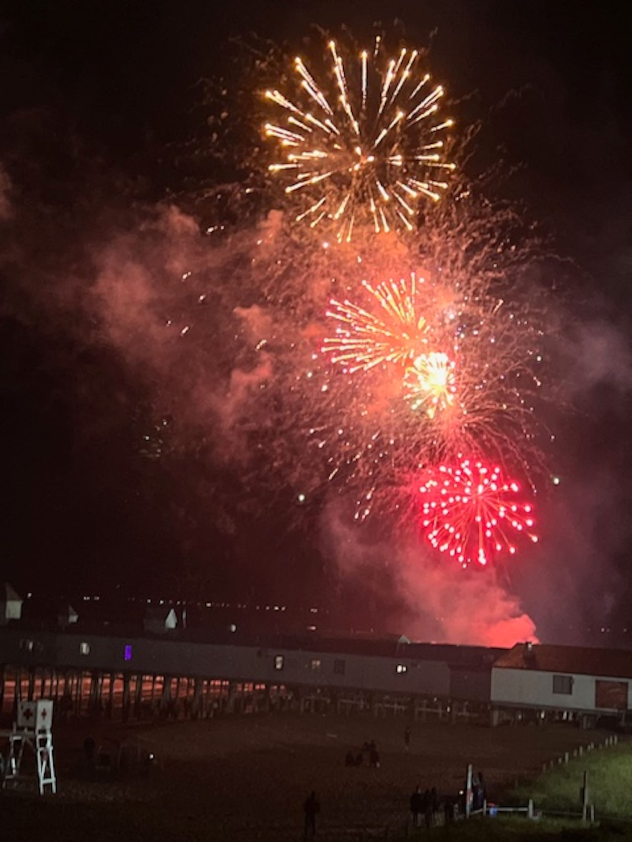 Fireworks bursting over the beach at night