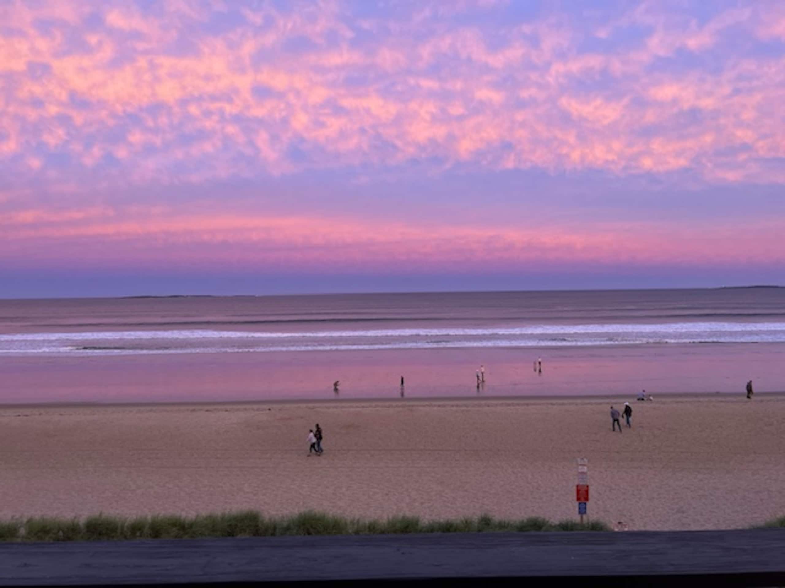 Beachgoers walking at sunset