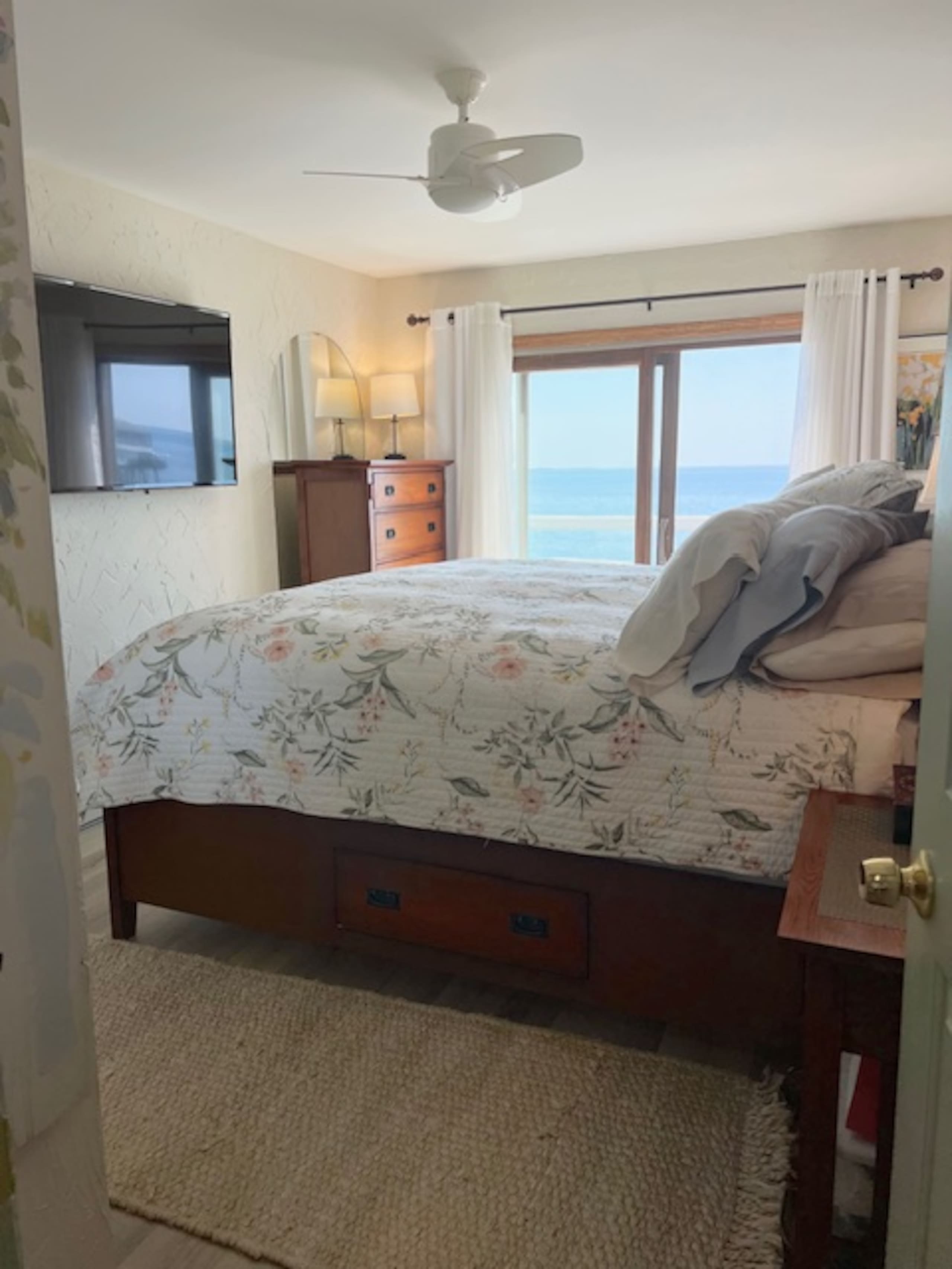 Primary bedroom with queen bed and ocean-view sliding door